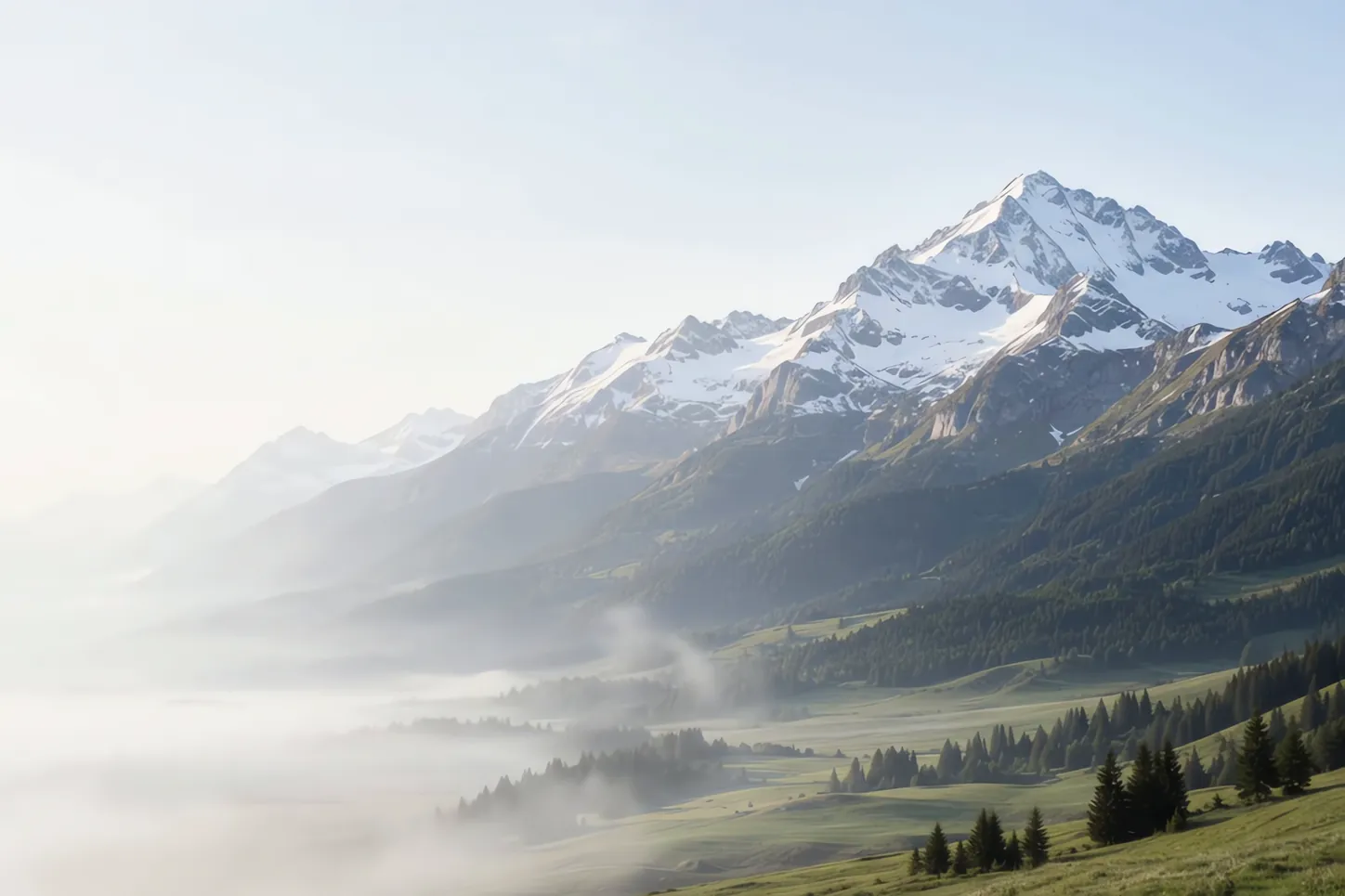 Um vale dos Alpes numa manhã clara, com picos nevados ao fundo e névoa sobre os campos.